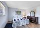 Bright bedroom featuring a blue-and-white patterned bedspread, wood floors, and natural light from two windows at 512 Maryland Ave, St Cloud, FL 34769