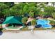 Community splash pad and playground shaded by a large green awning and surrounded by lush trees, benches and landscaping at 512 Maryland Ave, St Cloud, FL 34769