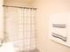 Bright bathroom featuring a shower-tub combo with a patterned curtain and a white towel set on the wall at 5506 Glen Lake Ln, Orlando, FL 32808