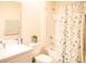 Bright bathroom featuring a vanity with a sink, a mirror, and a shower-tub combo with a floral curtain at 5506 Glen Lake Ln, Orlando, FL 32808