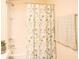 Bright bathroom featuring a shower-tub combo with a floral curtain and a green towel on the wall at 5506 Glen Lake Ln, Orlando, FL 32808