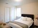 Bright bedroom featuring a large window, gray upholstered headboard, white bedding, and wood look floors at 5506 Glen Lake Ln, Orlando, FL 32808