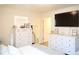 Bright bedroom featuring two large white dressers, wood look floors, and a large TV on the wall at 5506 Glen Lake Ln, Orlando, FL 32808