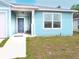 Light blue home with a welcoming front porch, gray front door, and a well-maintained lawn at 5506 Glen Lake Ln, Orlando, FL 32808