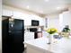 Bright kitchen with white cabinets, modern appliances and a view to the dining and living areas at 5506 Glen Lake Ln, Orlando, FL 32808