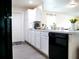 Well-lit kitchen featuring white cabinets, black appliances, and an open layout connecting to the living area at 5506 Glen Lake Ln, Orlando, FL 32808