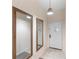 Hallway featuring two decorative mirrors and a white entry door beneath a woven pendant light at 607 Gran Bahama Blvd # B29/U607, Davenport, FL 33897