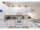 Well-lit kitchen featuring white cabinets, granite countertops, and modern appliances at 607 Gran Bahama Blvd # B29/U607, Davenport, FL 33897