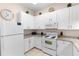 Bright kitchen boasts white cabinets, granite countertops, and modern white appliances at 607 Gran Bahama Blvd # B29/U607, Davenport, FL 33897