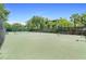 Outdoor tennis court featuring a green surface and surrounding fences and landscaping with building views at 607 Gran Bahama Blvd # B29/U607, Davenport, FL 33897
