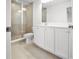 Bathroom features a glass shower, double sink vanity with white cabinets, and neutral tiling at 6501 Cyrils Dr, St Cloud, FL 34771