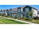 Townhomes boast colorful façades and landscaping with a well-maintained lawn at 6501 Cyrils Dr, St Cloud, FL 34771