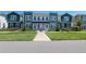 Inviting townhomes with green grass, concrete walkway, and colorful modern facades at 6501 Cyrils Dr, St Cloud, FL 34771