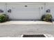 Attached white garage door on a sunny day with small bushes in front at 6501 Cyrils Dr, St Cloud, FL 34771