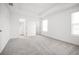 Main bedroom featuring plush gray carpeting, natural light, and an ensuite bathroom at 6501 Cyrils Dr, St Cloud, FL 34771