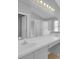 Bright bathroom featuring double sinks, a large mirror with vanity lighting, and a walk-in shower at 664 Eagle Pointe S, Kissimmee, FL 34746