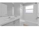 Clean bathroom featuring a shower and tub, a window, a toilet, and vanity with sink at 664 Eagle Pointe S, Kissimmee, FL 34746