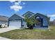 Charming blue single-story home featuring a well-maintained lawn, two car garage, and manicured landscaping at 664 Eagle Pointe S, Kissimmee, FL 34746