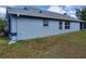 Side view of a light blue home with a well-maintained lawn and modern windows at 664 Eagle Pointe S, Kissimmee, FL 34746