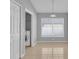 Bright hallway showcasing a washer and dryer closet, a window with blinds, and neutral-colored tile flooring at 664 Eagle Pointe S, Kissimmee, FL 34746