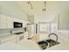Bright kitchen featuring white cabinets, appliances, tile flooring, and views of adjacent breakfast nook at 664 Eagle Pointe S, Kissimmee, FL 34746