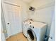 Convenient laundry room features a modern washer and dryer, with storage shelf and tile flooring at 664 Eagle Pointe S, Kissimmee, FL 34746