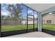 Enclosed lanai with views of the green backyard and a glimpse of neighboring homes at 664 Eagle Pointe S, Kissimmee, FL 34746