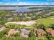Expansive aerial view showcasing beautiful homes nestled among mature trees, bordering a scenic golf course and lake at 6761 Valhalla Way, Windermere, FL 34786