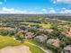 Aerial view of golf course community with homes, tree lined street, and distant lakes at 6761 Valhalla Way, Windermere, FL 34786