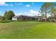 Spacious backyard showing the screened-in pool, verdant lawn, and partial home view at 6761 Valhalla Way, Windermere, FL 34786