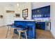 Stylish bar area boasts blue cabinets, seating, and a beverage refrigerator at 6761 Valhalla Way, Windermere, FL 34786