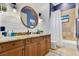 Well-appointed bathroom featuring wood panels, shower, and granite countertop at 6761 Valhalla Way, Windermere, FL 34786