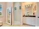 Bathroom showcasing a large mirror, decorative tile shower and custom vanity with granite countertops at 6761 Valhalla Way, Windermere, FL 34786