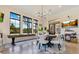 Large dining area with round table, modern chandelier, shuffleboard, and multiple windows at 6761 Valhalla Way, Windermere, FL 34786