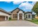 Beautiful home with stone accents, a brick driveway, and a three-car garage at 6761 Valhalla Way, Windermere, FL 34786