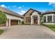 Beautiful home with stone accents, a brick driveway, and a three-car garage at 6761 Valhalla Way, Windermere, FL 34786