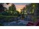 Serene backyard with bistro seating, lush greenery, and festive string lights, ideal for evening gatherings at 6970 Piazza St, Orlando, FL 32819