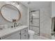 Stylish bathroom with marble-look walls, frameless glass shower, and gray vanity at 6970 Piazza St, Orlando, FL 32819