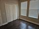 Bedroom with wood flooring and two windows that provide natural light, as well as a closet at 7673 Ripplepointe Way, Windermere, FL 34786