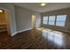 Bedroom featuring wood floors, neutral walls, and three windows for ample natural light at 7673 Ripplepointe Way, Windermere, FL 34786