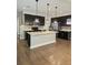 Well-lit kitchen featuring a center island, stainless steel appliances, hardwood floors and modern light fixtures at 7673 Ripplepointe Way, Windermere, FL 34786