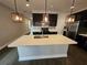 Kitchen with center island, stainless steel appliances, hardwood floors and modern pendant lighting at 7673 Ripplepointe Way, Windermere, FL 34786