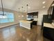 Open kitchen featuring hardwood floors, center island, stainless steel appliances and natural light at 7673 Ripplepointe Way, Windermere, FL 34786
