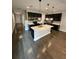 Modern kitchen with an island, black cabinets, stainless steel appliances, and hardwood floors at 7673 Ripplepointe Way, Windermere, FL 34786