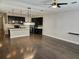 Open-concept layout showcasing the kitchen and living area with hardwood floors and natural lighting at 7673 Ripplepointe Way, Windermere, FL 34786
