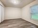 A bright bedroom with new wood-look flooring and a window providing natural light at 7865 Sugar View Ct # 7865, Orlando, FL 32819