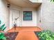 Inviting condo entryway featuring a white front door, security door, terracotta-colored walkway, and lush landscaping at 7865 Sugar View Ct # 7865, Orlando, FL 32819