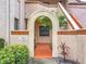 Inviting condo entrance with stucco archway, mature landscaping, terracotta-colored walkway, and tile accents at 7865 Sugar View Ct # 7865, Orlando, FL 32819
