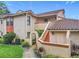 Charming two-story condo with terracotta tile roof, stucco exterior, and inviting entrance with colorful stairway at 7865 Sugar View Ct # 7865, Orlando, FL 32819