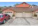 Charming condo featuring multi-car garage with neutral tone doors, orange-colored stucco, and Spanish tile roofing at 7865 Sugar View Ct # 7865, Orlando, FL 32819